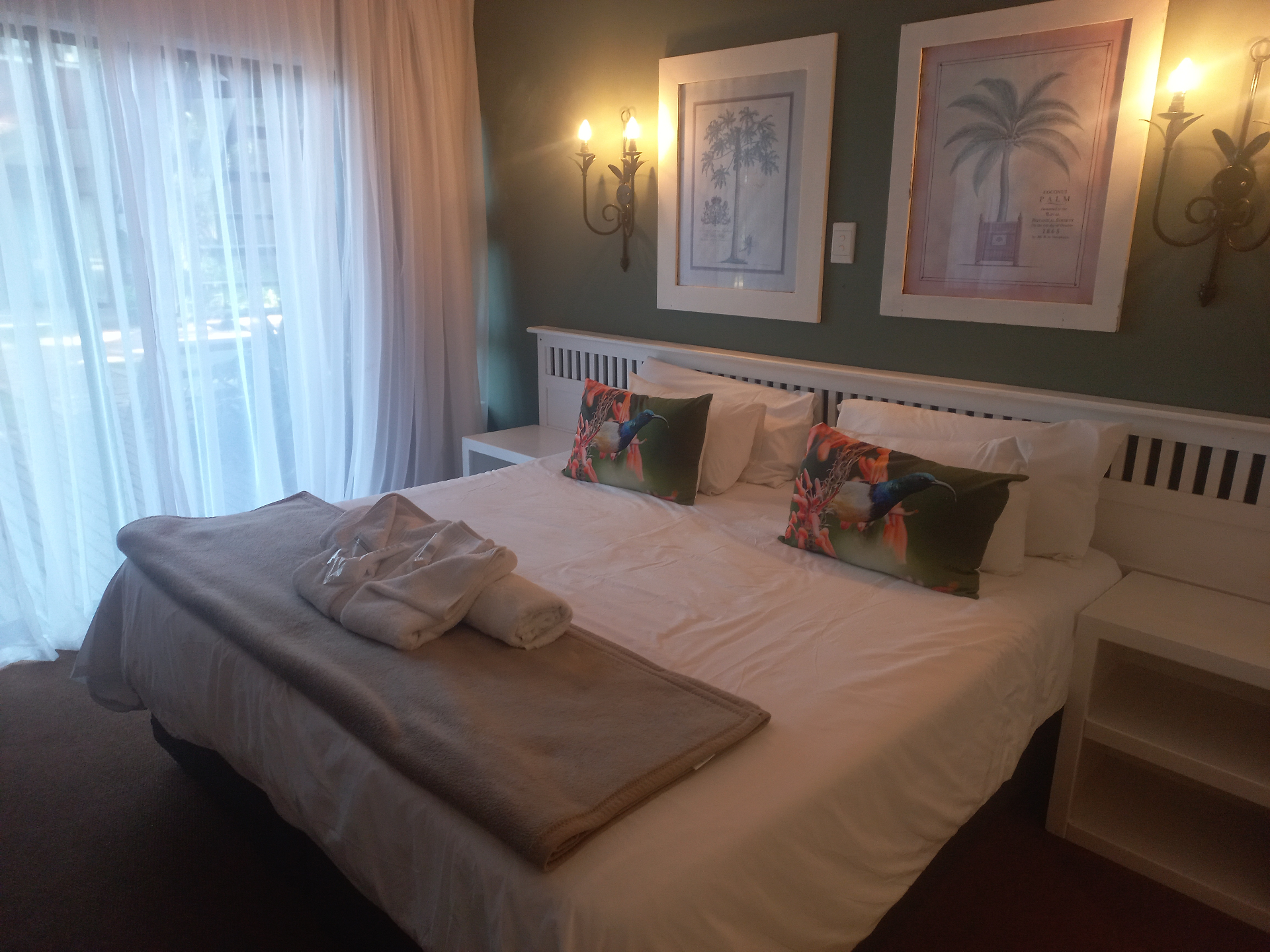 Raphia room with garden-facing curtains and a neatly made bed.